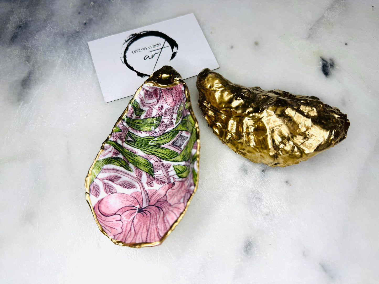 Single handcrafted Dorset oyster shell trinket dish featuring the William Morris Pink Pimpernel design in pink and green tones, edged with liquid gold leaf and sealed in glossy resin. Sold individually, this natural oyster shell jewellery holder is ideal for rings or earrings and makes a unique coastal gift or wedding favour.