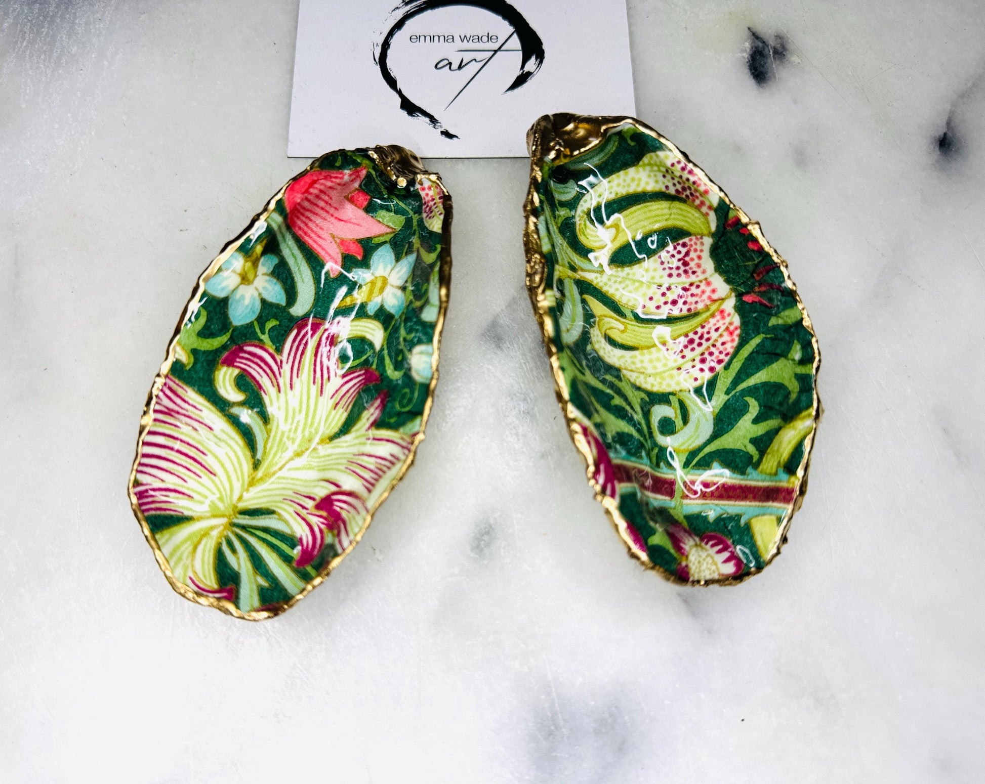 Hand finished Dorset oyster shell trinket dish featuring William Morris Golden Lily design, edged with real gold leaf and sealed with high gloss resin. Decorative jewellery dish styled on marble background, ideal as ring holder, coastal home decor accent or luxury wedding and bridesmaid gift.