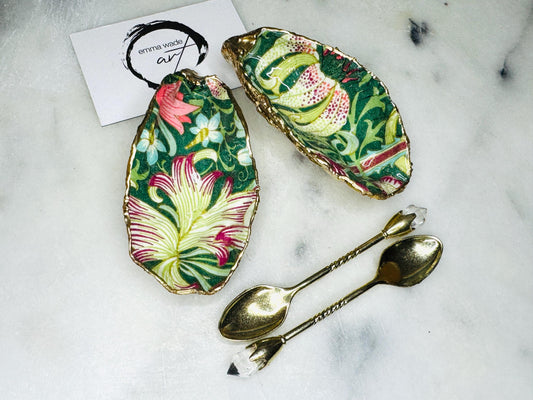 Pair of William Morris Green Pimpernel oyster shell salt and pepper dishes, hand finished Dorset cupped shells with liquid gold leaf edging and high gloss resin finish. Decorative coastal cruet set styled on marble surface with gold spoons, ideal for wedding table décor, anniversary gift or luxury dinner party setting.