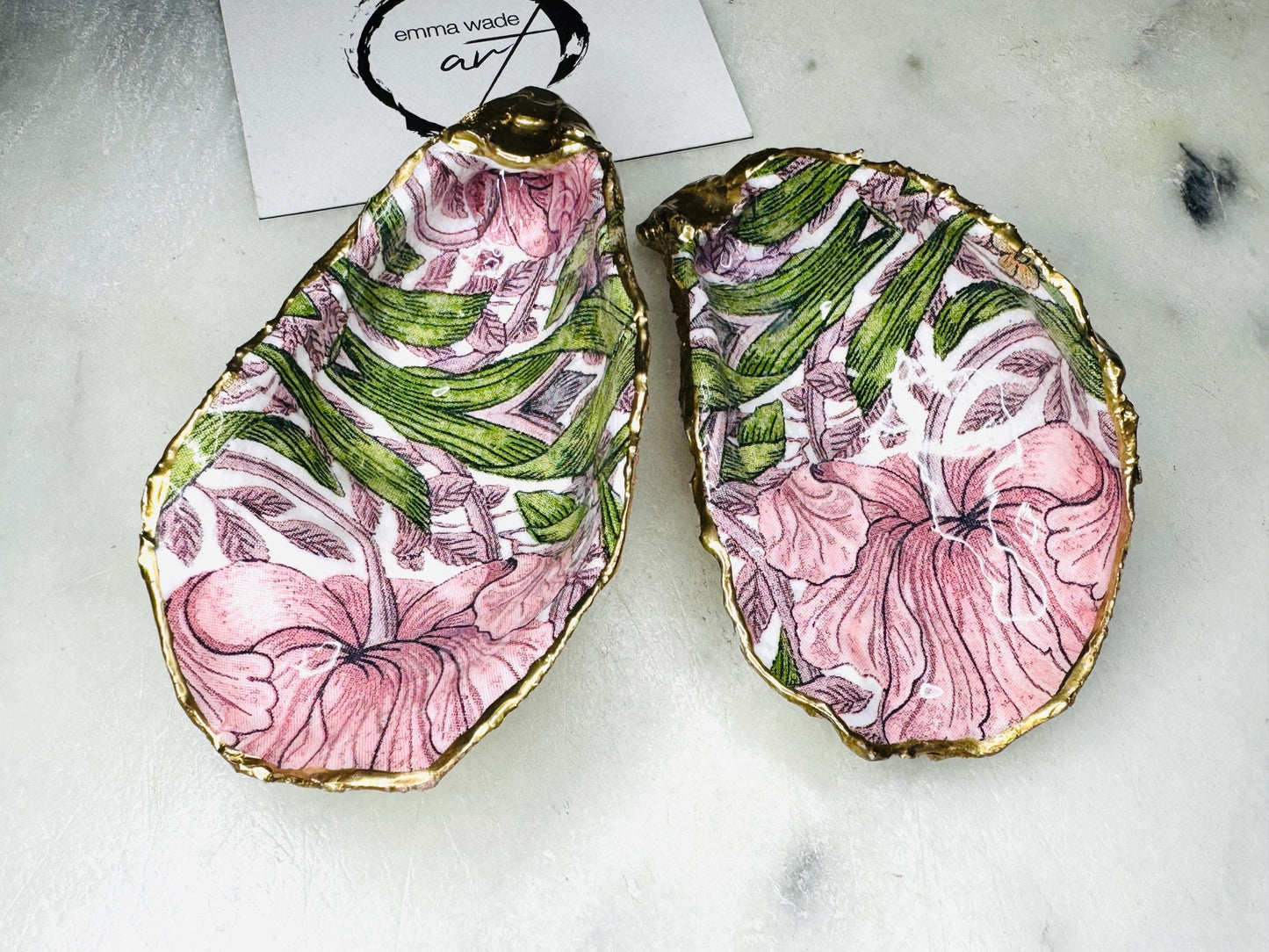 Single handcrafted Dorset oyster shell trinket dish featuring the William Morris Pink Pimpernel design in pink and green tones, edged with liquid gold leaf and sealed in glossy resin. Sold individually, this natural oyster shell jewellery holder is ideal for rings or earrings and makes a unique coastal gift or wedding favour.