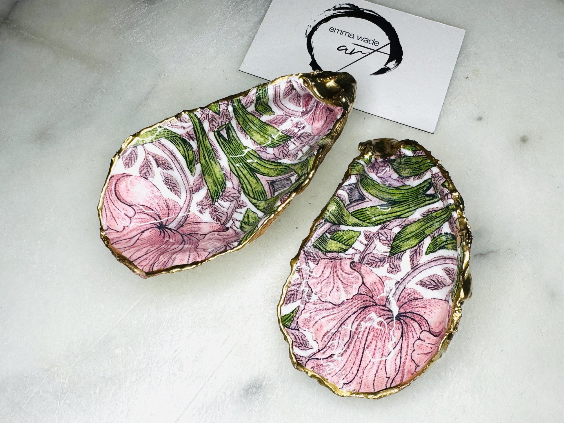 Single handcrafted Dorset oyster shell trinket dish featuring the William Morris Pink Pimpernel design in pink and green tones, edged with liquid gold leaf and sealed in glossy resin. Sold individually, this natural oyster shell jewellery holder is ideal for rings or earrings and makes a unique coastal gift or wedding favour.