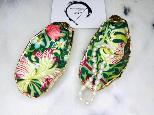 Hand finished Dorset oyster shell trinket dish featuring William Morris Golden Lily design, edged with real gold leaf and sealed with high gloss resin. Decorative jewellery dish styled on marble background, ideal as ring holder, coastal home decor accent or luxury wedding and bridesmaid gift.