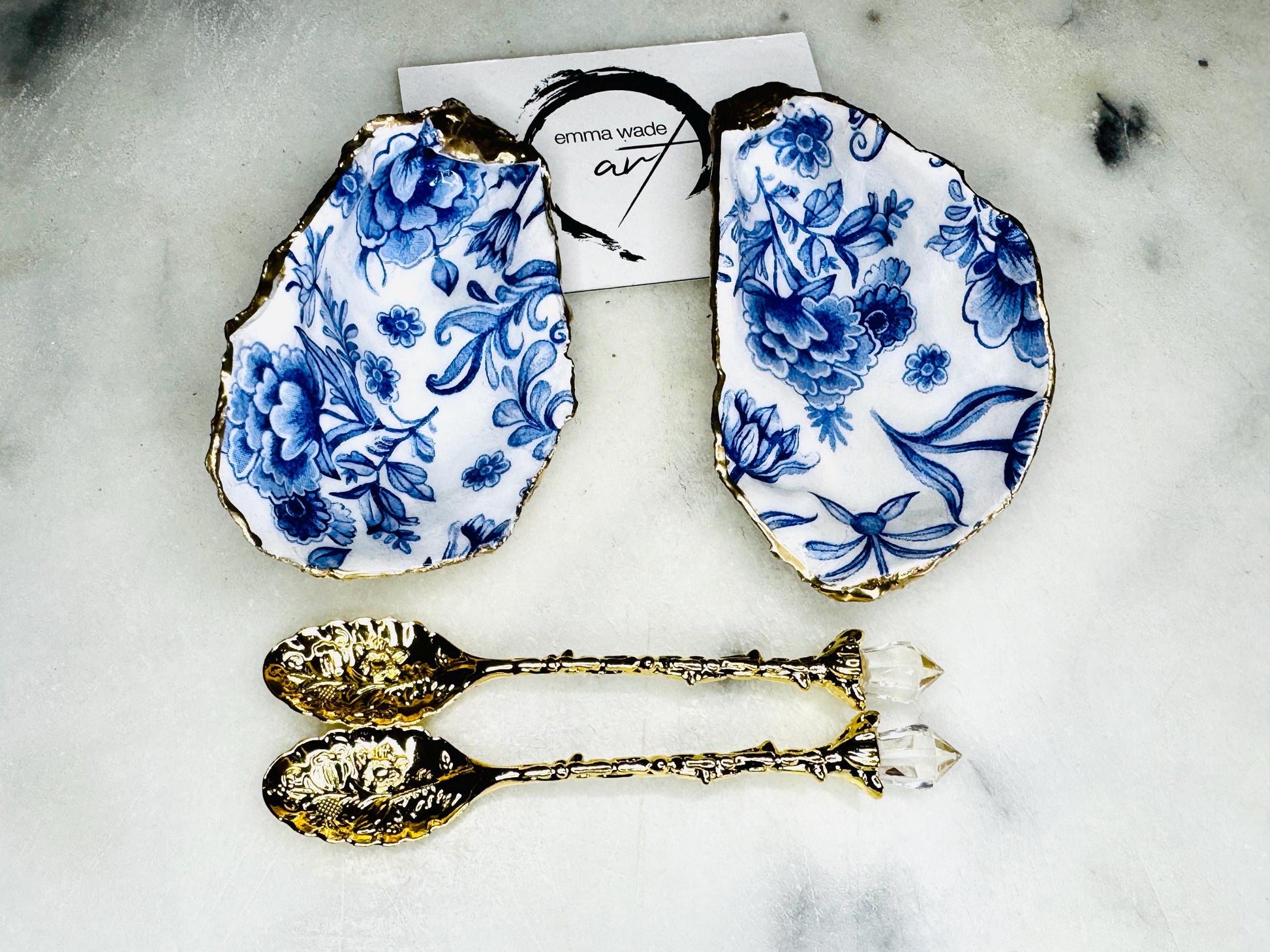 Pair of handmade Delft Blue oyster shell salt cellar set with blue and white floral pattern, gold leaf edging and matching gold crystal spoons. Coastal oyster shell pinch pots finished in glossy resin for elegant table decor
