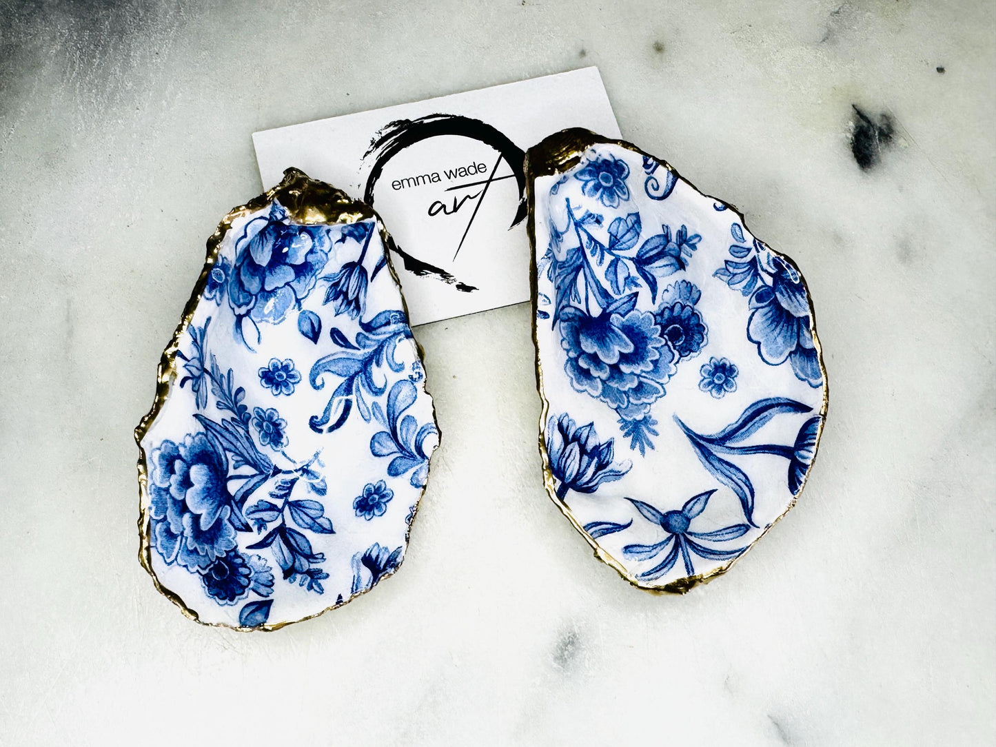 Pair of handmade Delft Blue oyster shell salt cellar set with blue and white floral pattern, gold leaf edging and matching gold crystal spoons. Coastal oyster shell pinch pots finished in glossy resin for elegant table decor