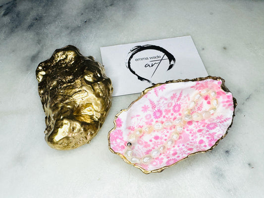 Pink lily oyster shell jewellery dish with gold leaf trim. A unique shell ring holder, trinket dish, or shell ring tray made from natural Dorset shells. Each dish has a floral design and varies slightly in size and shape. Perfect for storing rings, earrings, cufflinks, or small keepsakes. Can also be used as a tealight holder, spoon rest, or salt pinch pot. A beautiful wedding gift, bridesmaid favour, birthday present, or coastal-inspired home accessory.