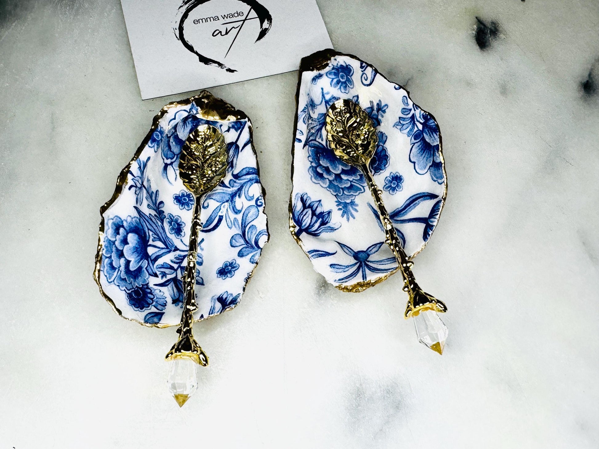 Pair of handmade Delft Blue oyster shell salt cellar set with blue and white floral pattern, gold leaf edging and matching gold crystal spoons. Coastal oyster shell pinch pots finished in glossy resin for elegant table decor