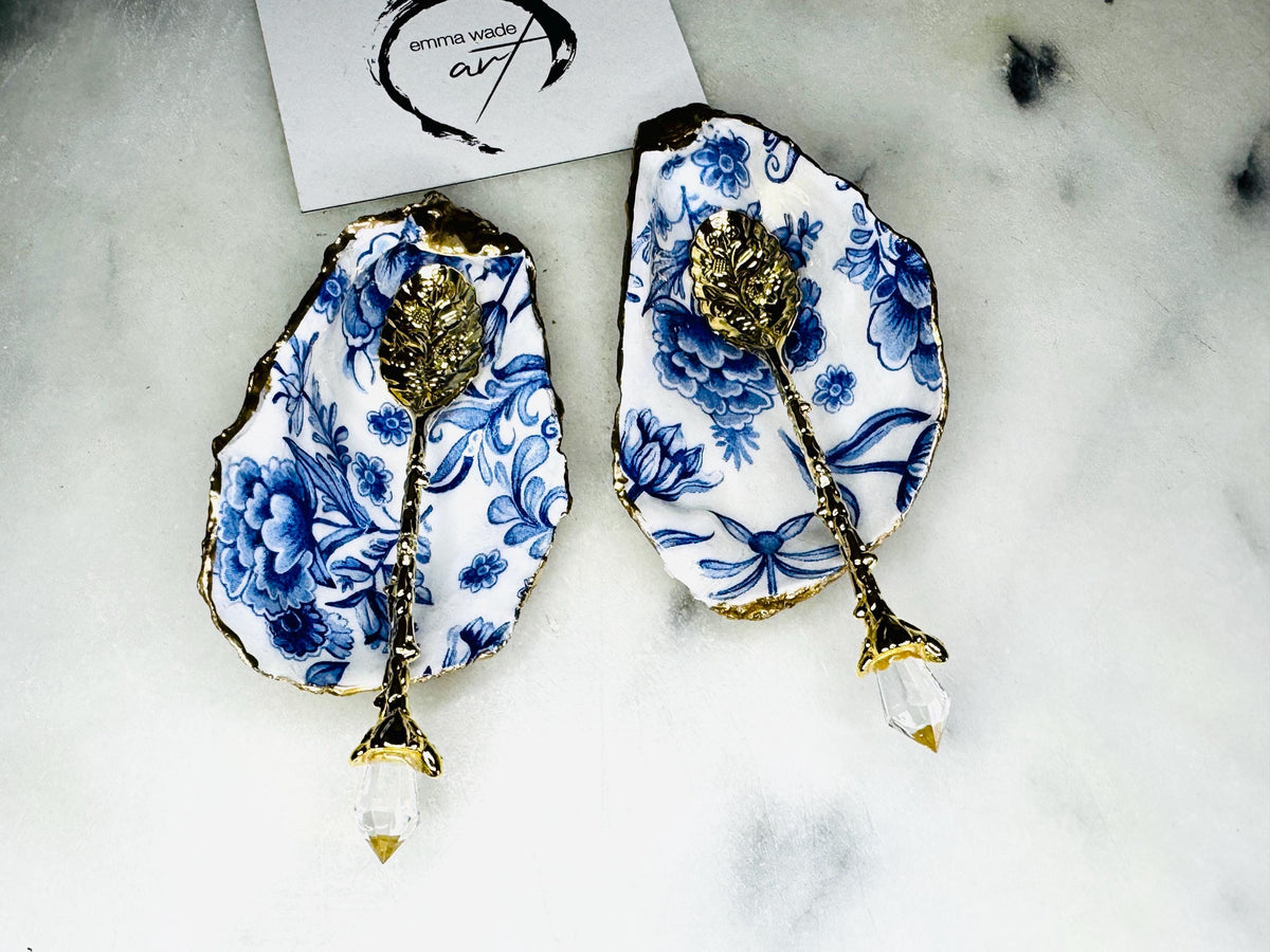 Pair of handmade Delft Blue oyster shell salt cellar set with blue and white floral pattern, gold leaf edging and matching gold crystal spoons. Coastal oyster shell pinch pots finished in glossy resin for elegant table decor