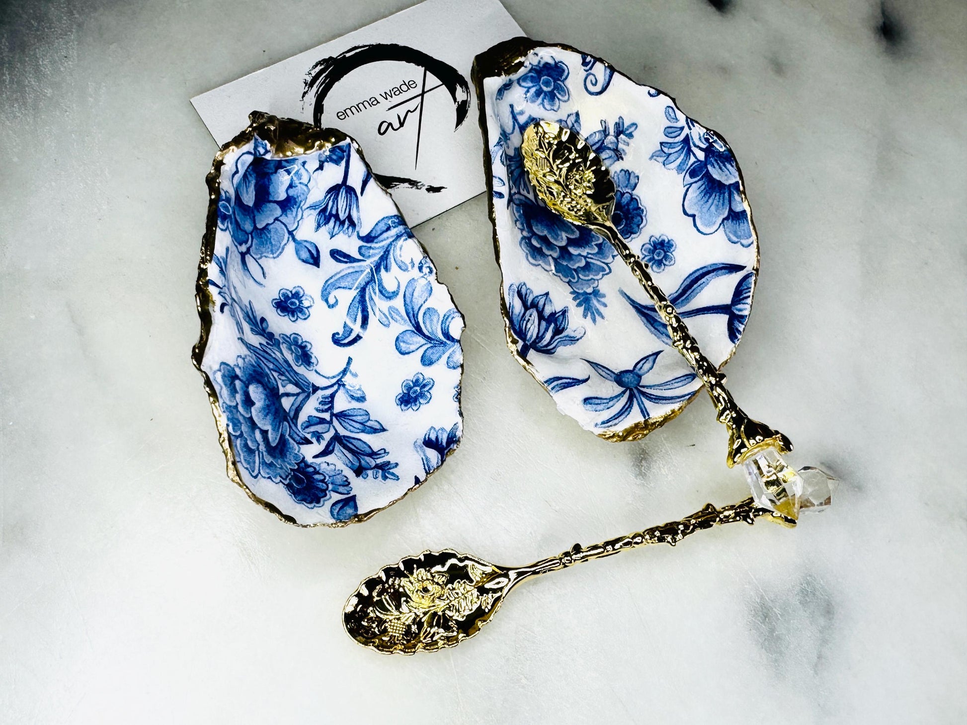 Pair of handmade Delft Blue oyster shell salt cellar set with blue and white floral pattern, gold leaf edging and matching gold crystal spoons. Coastal oyster shell pinch pots finished in glossy resin for elegant table decor