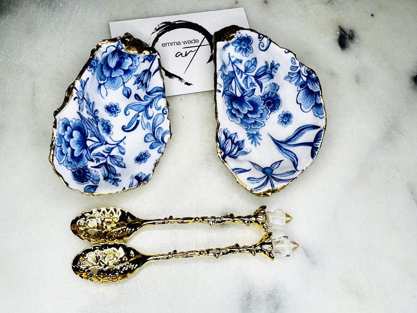 Pair of handmade Delft Blue oyster shell salt cellar set with blue and white floral pattern, gold leaf edging and matching gold crystal spoons. Coastal oyster shell pinch pots finished in glossy resin for elegant table decor