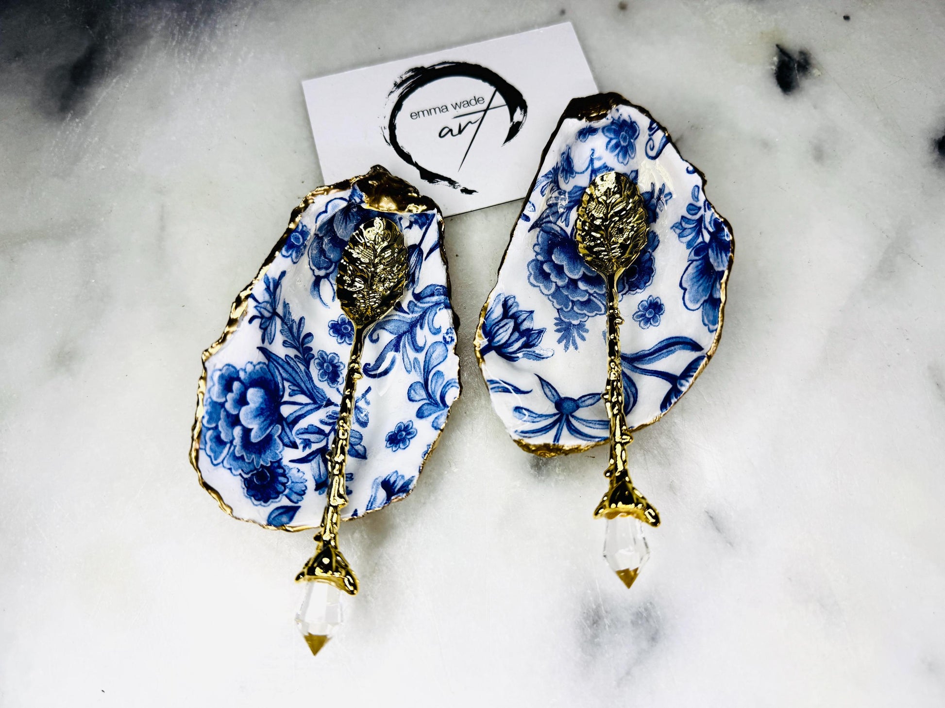 Pair of handmade Delft Blue oyster shell salt cellar set with blue and white floral pattern, gold leaf edging and matching gold crystal spoons. Coastal oyster shell pinch pots finished in glossy resin for elegant table decor