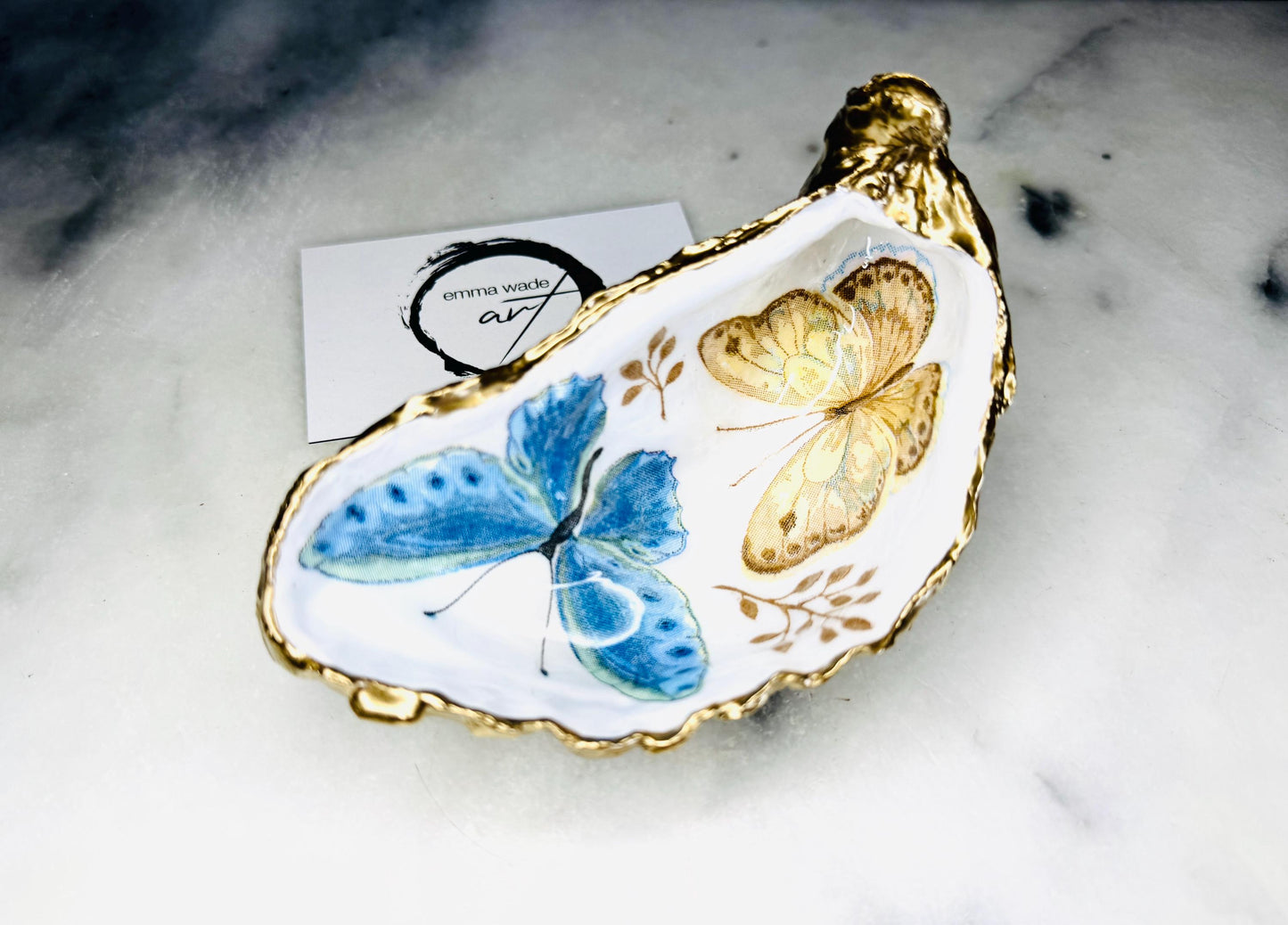 Blue yellow green butterfly oyster shell trinket dish handmade from Dorset coast shell, gold leaf gilded rim and back, high gloss resin interior with colourful butterfly design, coastal home decor jewellery dish, ring holder, trinket tray, seaside gift for her, handmade shell decor, luxury coastal accessory, unique artisan gift UK