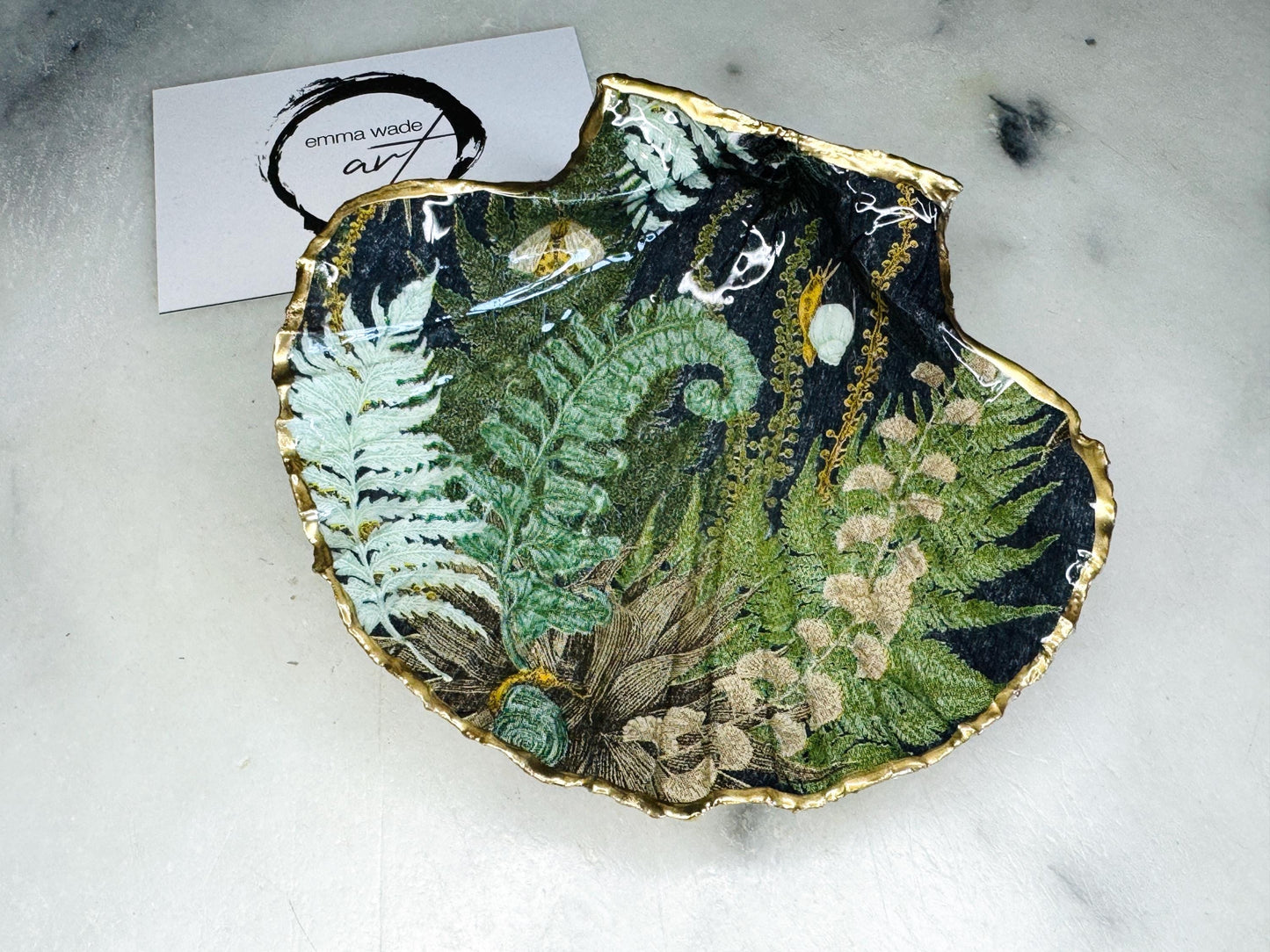 Handmade fern green scallop shell trinket dish with botanical forest fern design, gold leaf edging, and glossy resin finish. Natural Dorset shell jewellery dish inspired by woodland décor and cottagecore interiors, styled as a ring holder, trinket tray, or coastal nature-inspired gift.