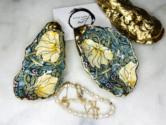 William Morris Golden Green Pimpernel oyster shell ring dish with gold leaf edge. A unique shell ring holder, ring tray, and jewellery organiser for rings, earrings, or cufflinks. Each shell features an art inspired floral design and is individually handmade from Dorset shells. Perfect as a trinket dish for bedside or dressing table storage. A thoughtful gift for weddings, anniversaries, birthdays, bridesmaids, or Christmas. A sustainable decorative keepsake for any jewellery lover.