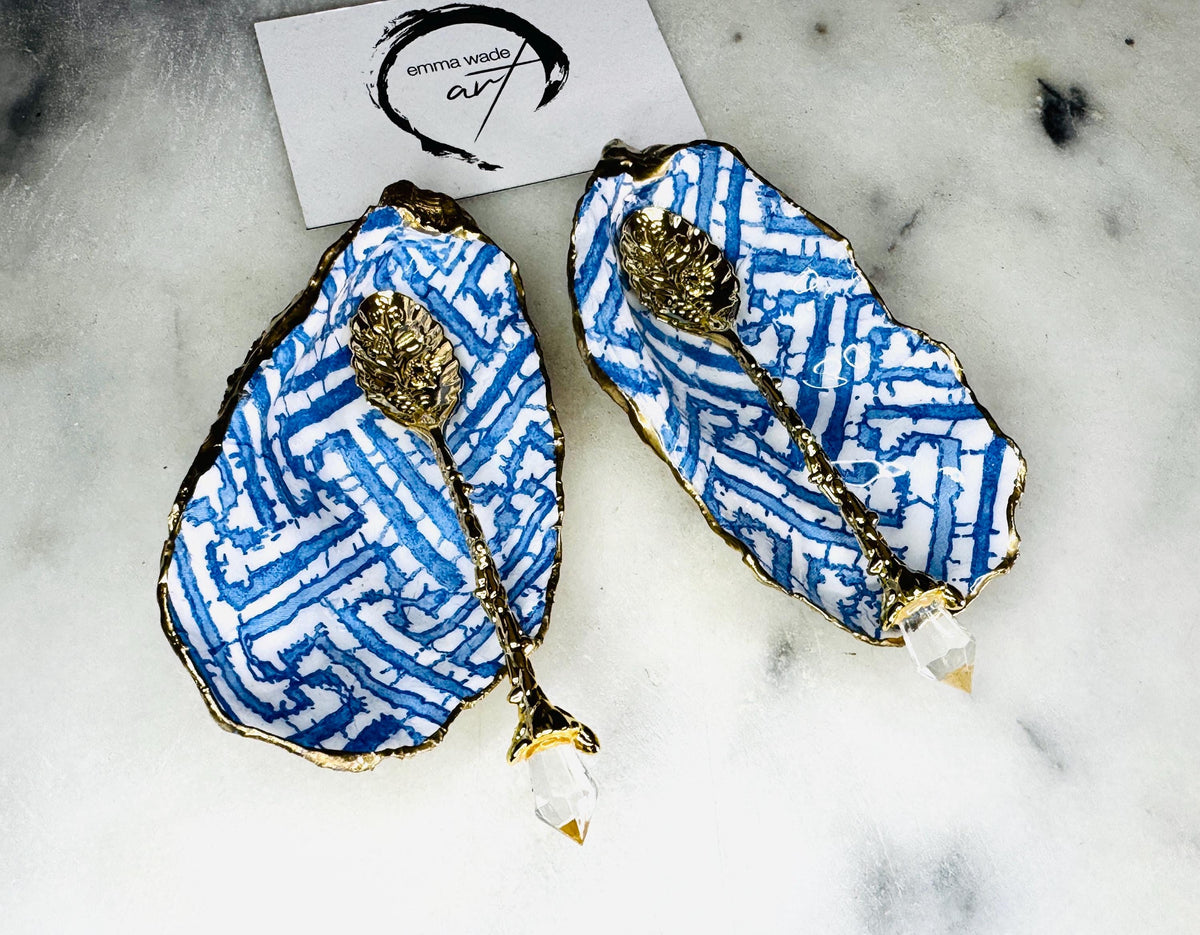 Handmade blue fretwork oyster shell salt and pepper pinch pots shown as a matching pair with small gold spoons, crafted from natural Dorset oyster shells. Each shell features a striking blue fretwork maze pattern, sealed with crystal-clear food-safe resin and finished with shimmering gold leaf edges. Coastal-inspired shell cruet dishes, perfect for table decor, weddings, or a unique luxury hostess gift, with each piece one of a kind.
