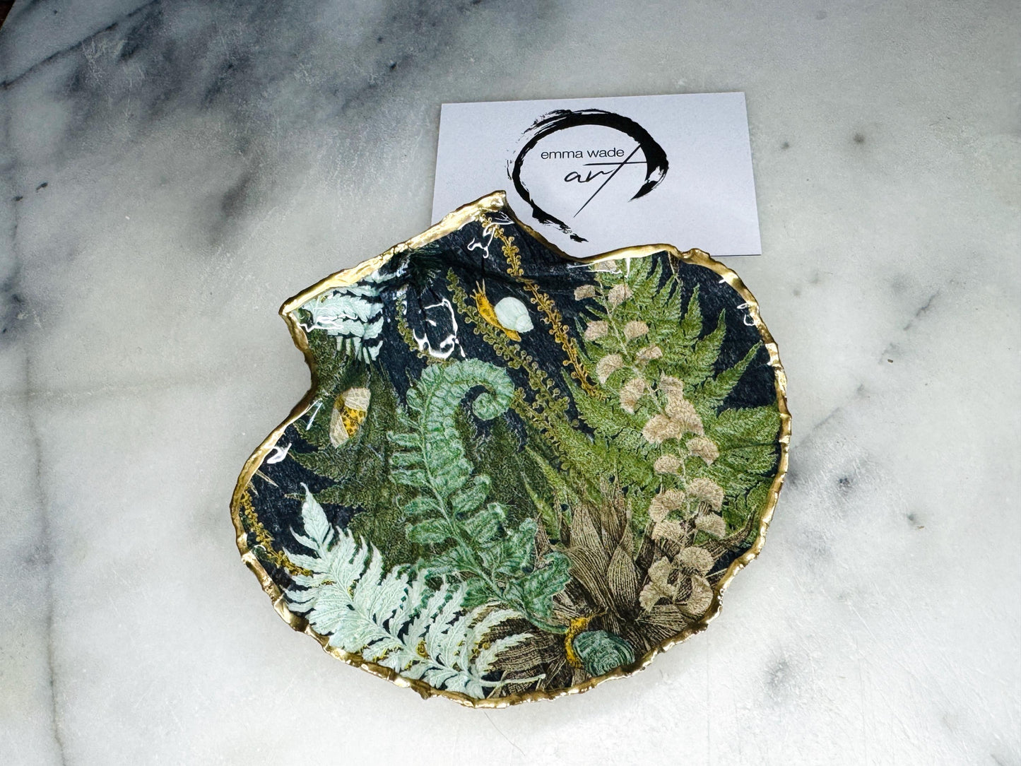 Handmade fern green scallop shell trinket dish with botanical forest fern design, gold leaf edging, and glossy resin finish. Natural Dorset shell jewellery dish inspired by woodland décor and cottagecore interiors, styled as a ring holder, trinket tray, or coastal nature-inspired gift.
