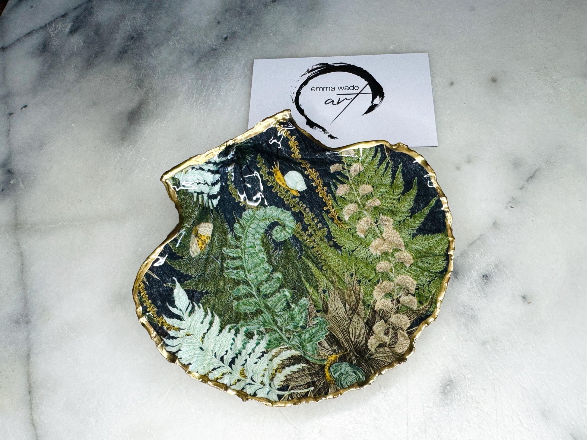 Handmade fern green scallop shell trinket dish with botanical forest fern design, gold leaf edging, and glossy resin finish. Natural Dorset shell jewellery dish inspired by woodland décor and cottagecore interiors, styled as a ring holder, trinket tray, or coastal nature-inspired gift.