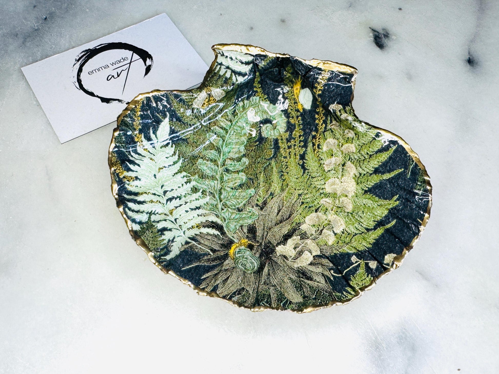 Handmade fern green scallop shell trinket dish with botanical forest fern design, gold leaf edging, and glossy resin finish. Natural Dorset shell jewellery dish inspired by woodland décor and cottagecore interiors, styled as a ring holder, trinket tray, or coastal nature-inspired gift.