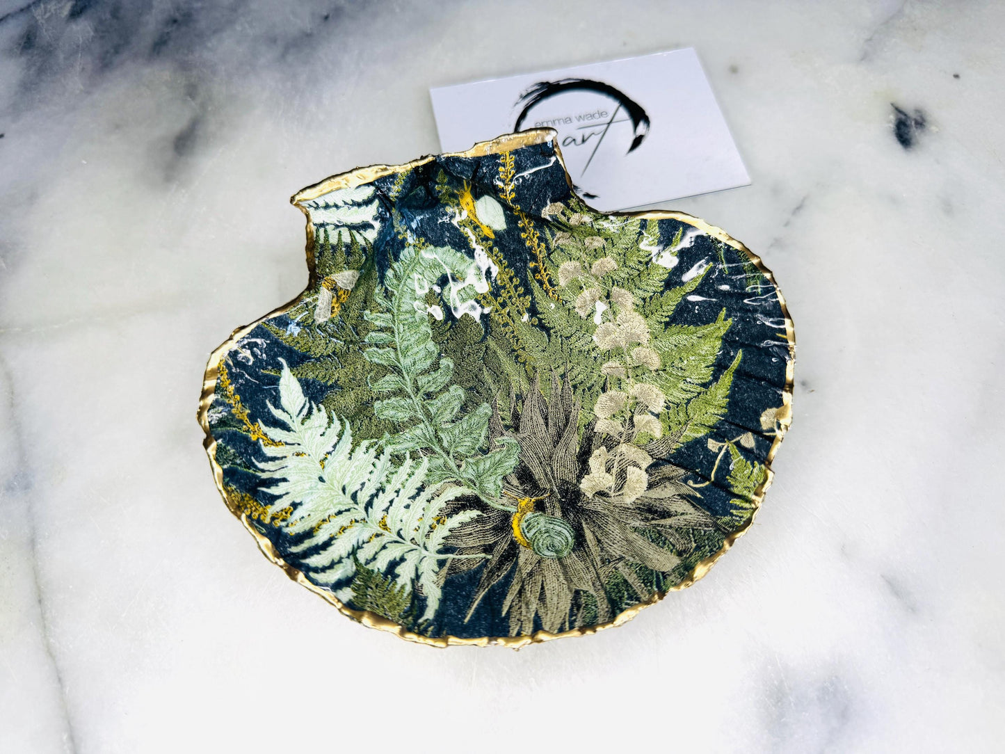 Handmade fern green scallop shell trinket dish with botanical forest fern design, gold leaf edging, and glossy resin finish. Natural Dorset shell jewellery dish inspired by woodland décor and cottagecore interiors, styled as a ring holder, trinket tray, or coastal nature-inspired gift.