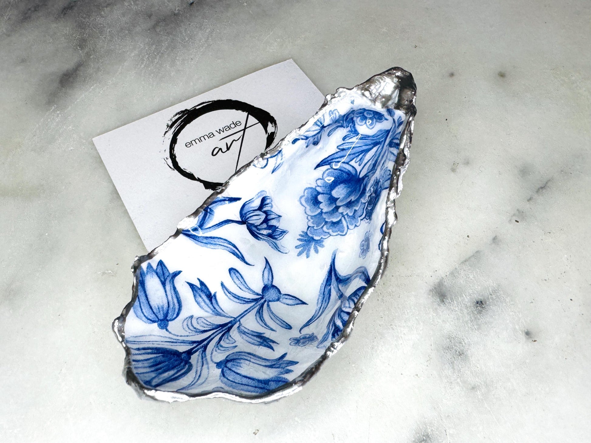Delft blue floral oyster shell dish, handmade Dorset oyster shell trinket dish, gold leaf oyster shell jewellery holder, silver gilded oyster shell ornament, blue and white floral oyster shell decor, sustainable coastal oyster shell gift, artisan oyster shell jewellery tray UK, Delft blue oyster shell salt and pepper pinch pot, oyster shell spoon rest, handmade floral oyster shell vanity dish, Delft inspired coastal oyster shell ornament, unique oyster shell gift for wedding or anniversary
