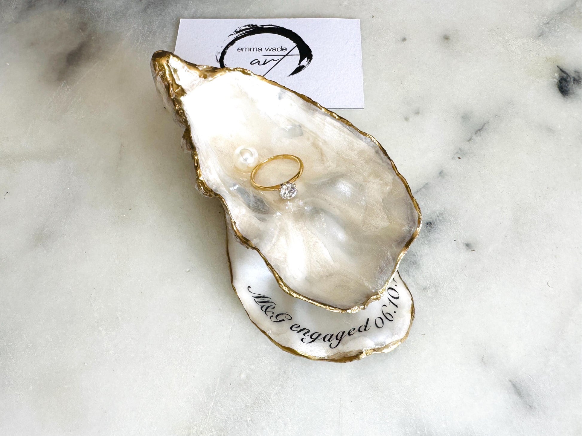 Handmade Dorset oyster shell jewellery dish set with a cupped oyster shell resting on a flat shell base, finished with natural pearl interiors and gold leaf edging. Personalised coastal trinket dish handcrafted in the UK, ideal for holding rings or jewellery. Elegant shell decor presented in sustainable gift packaging, perfect for weddings, anniversaries or special occasions.