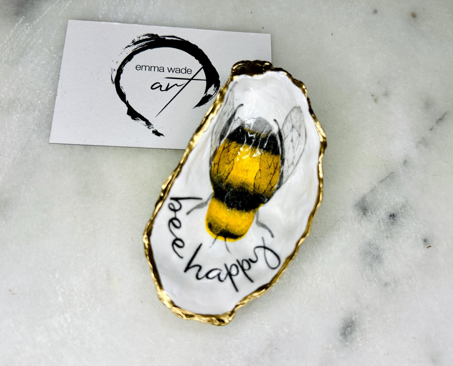 bee happy oyster shell trinket dish, Dorset oyster shell jewellery holder, handmade bee design coastal decor, gold leaf gilded oyster shell ornament, sustainable oyster shell dish UK, bumble bee oyster shell jewellery tray, nature inspired bee oyster shell gift, eco friendly oyster shell bathroom accessory, oyster shell salt and pepper pinch pot, unique bee themed oyster shell keepsake, handmade Dorset oyster shell decor, bee lover jewellery dish gift, coastal oyster shell art UK