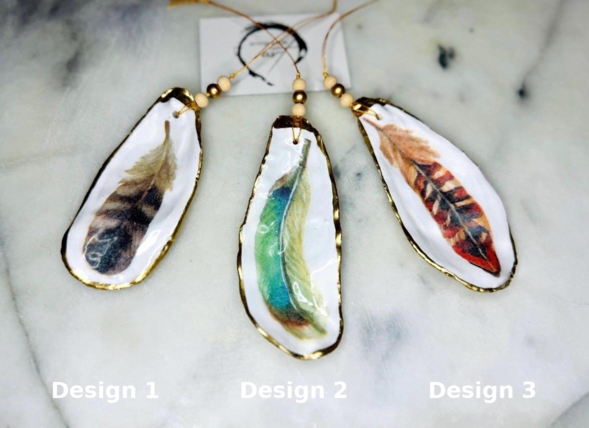 Aquarelle feather oyster shell hanging ornaments, handmade coastal décor, gilded gold leaf shells, resin sealed feather decorations, Christmas tree ornaments, nature-inspired gifts, watercolor feather oyster shells, Dorset handmade shell ornaments, sustainable coastal gifts, oyster shell art, feather design decorations, unique shell ornaments, eco-friendly handmade oyster shell Christmas gifts.