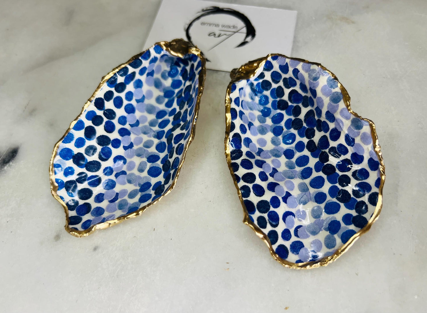 Handmade Emma Bridgewater Blue Dots oyster shell trinket dish, shown as a single jewellery tray with a blue and white dot pattern and hand-gilded gold leaf edges. Crafted from a natural Dorset oyster shell and sealed with glossy, crystal-clear resin. Coastal-inspired home decor, perfect for holding rings, earrings and small keepsakes, with each shell one of a kind and finished by hand.