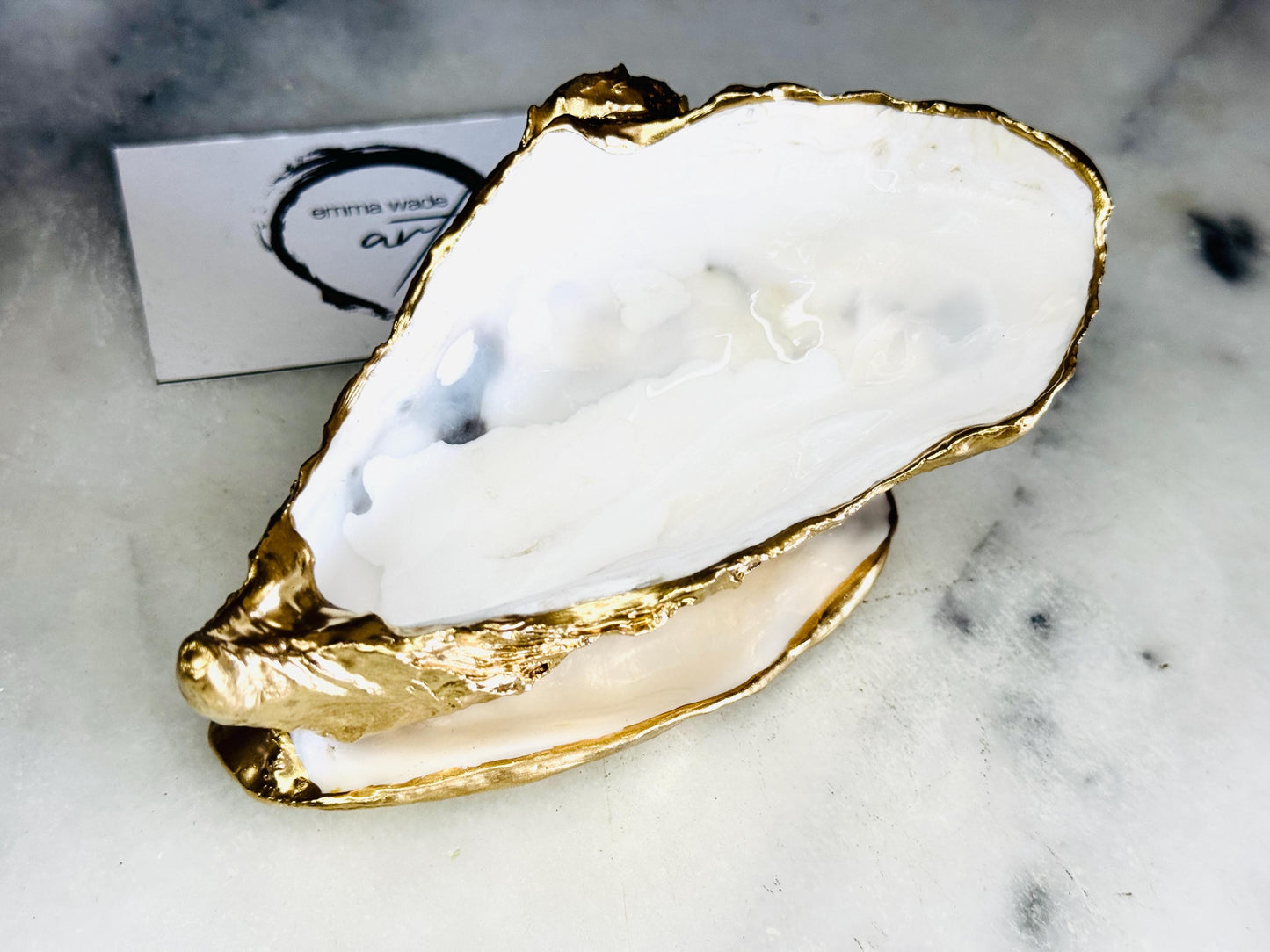Extra large Dorset oyster shell serving dish set with natural pearl interior and hand-applied gold leaf edging, featuring a cupped XL oyster shell with matching flat shell base. Luxury coastal home décor ideal as a sugar dish, serving bowl, coffee station accessory, or elegant host gift. Handmade using sustainably sourced UK oyster shells and finished with glossy resin and optional gold serving accessories.