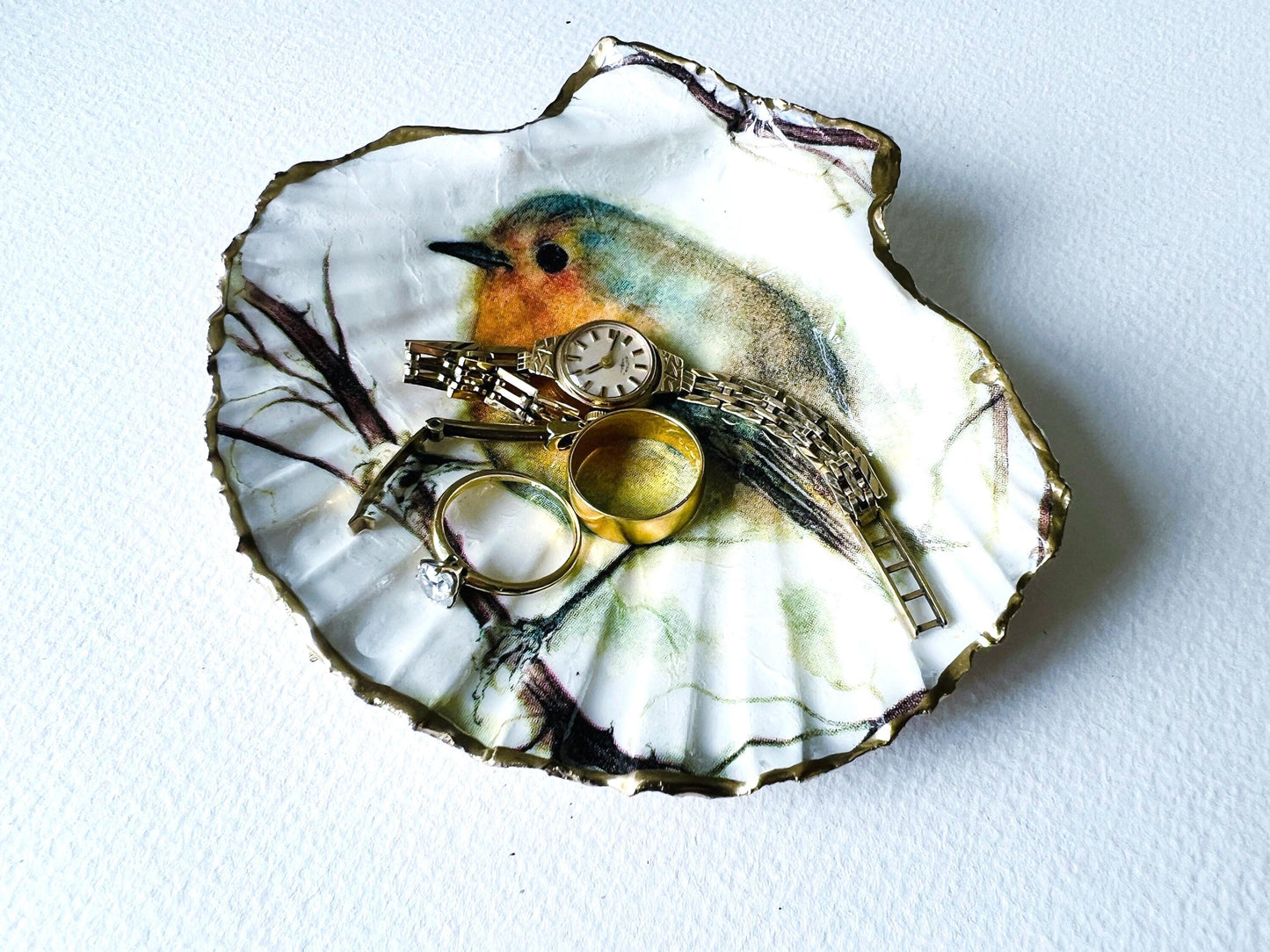 UK Robin Redbreast scallop shell gift. Handmade bird shell ornament or jewellery dish. Dorset scallop shell, gilded with real gold leaf and sealed with resin. Perfect UK Christmas decoration, festive stocking filler, or bird lover gift. Use as ring dish, trinket dish, cufflink holder, or coastal home décor. Eco-friendly handmade UK shell craft. Ideal gift for birthdays, weddings, anniversaries, or nature lovers.
