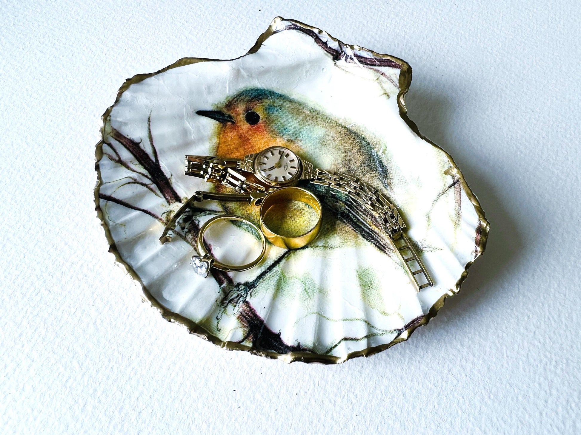 UK Robin Redbreast scallop shell gift. Handmade bird shell ornament or jewellery dish. Dorset scallop shell, gilded with real gold leaf and sealed with resin. Perfect UK Christmas decoration, festive stocking filler, or bird lover gift. Use as ring dish, trinket dish, cufflink holder, or coastal home décor. Eco-friendly handmade UK shell craft. Ideal gift for birthdays, weddings, anniversaries, or nature lovers.