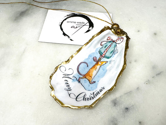 Handmade Dorset oyster shell Christmas ornament featuring a whimsical festive mouse illustration with gold leaf edging, glossy resin finish, and hanging ribbon. Coastal Christmas decoration styled as a luxury handmade oyster shell bauble and festive trinket keepsake gift.