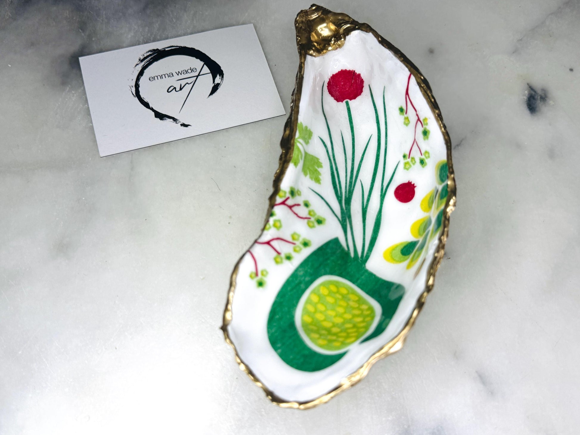 Handmade Dorset oyster shell trinket dish featuring colourful garden fruit artwork in green, yellow, and red tones with hand-gilded gold leaf edging and glossy resin finish. Coastal jewellery holder and botanical home décor gift.