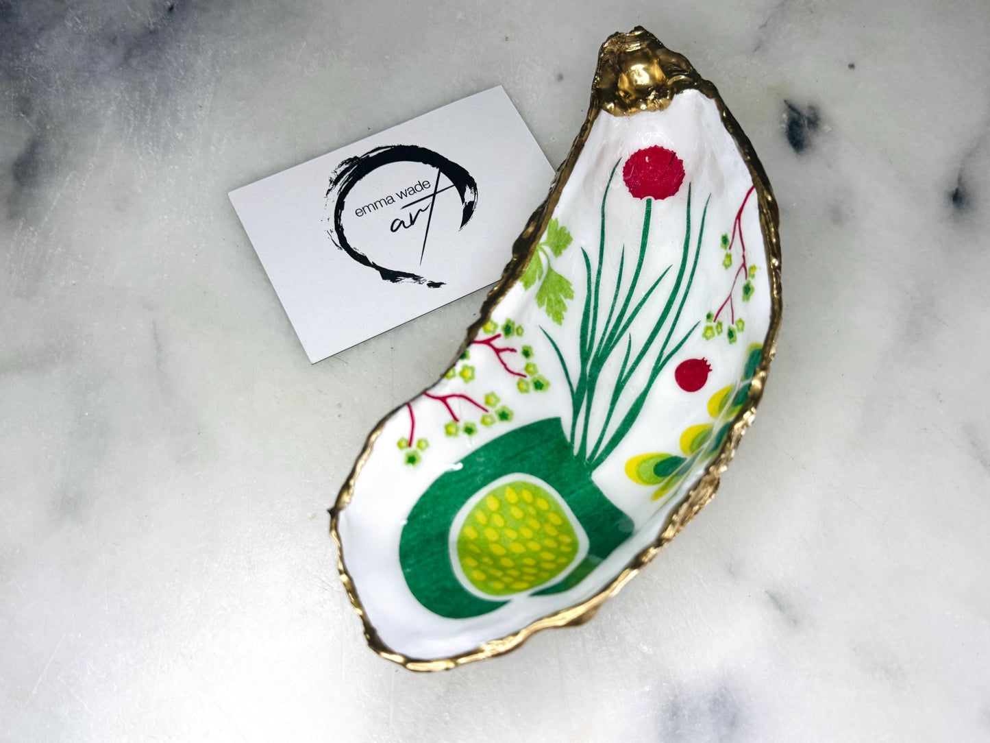 Handmade Dorset oyster shell trinket dish featuring colourful garden fruit artwork in green, yellow, and red tones with hand-gilded gold leaf edging and glossy resin finish. Coastal jewellery holder and botanical home décor gift.