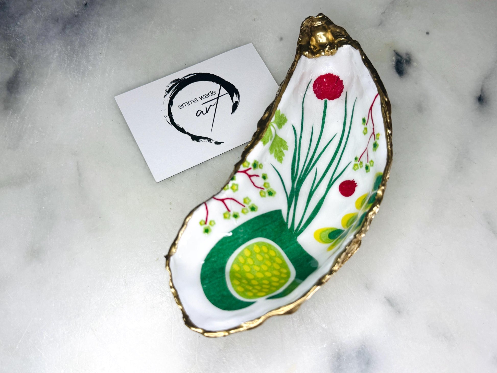 Handmade Dorset oyster shell trinket dish featuring colourful garden fruit artwork in green, yellow, and red tones with hand-gilded gold leaf edging and glossy resin finish. Coastal jewellery holder and botanical home décor gift.
