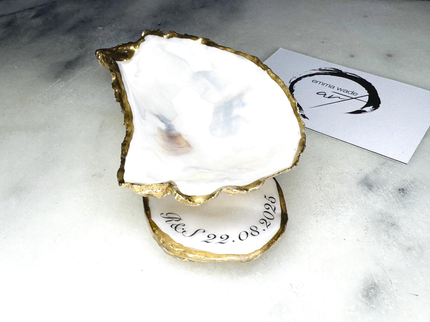 Handmade Dorset oyster shell jewellery dish set with a cupped oyster shell resting on a flat shell base, finished with natural pearl interiors and gold leaf edging. Personalised coastal trinket dish handcrafted in the UK, ideal for holding rings or jewellery. Elegant shell decor presented in sustainable gift packaging, perfect for weddings, anniversaries or special occasions.