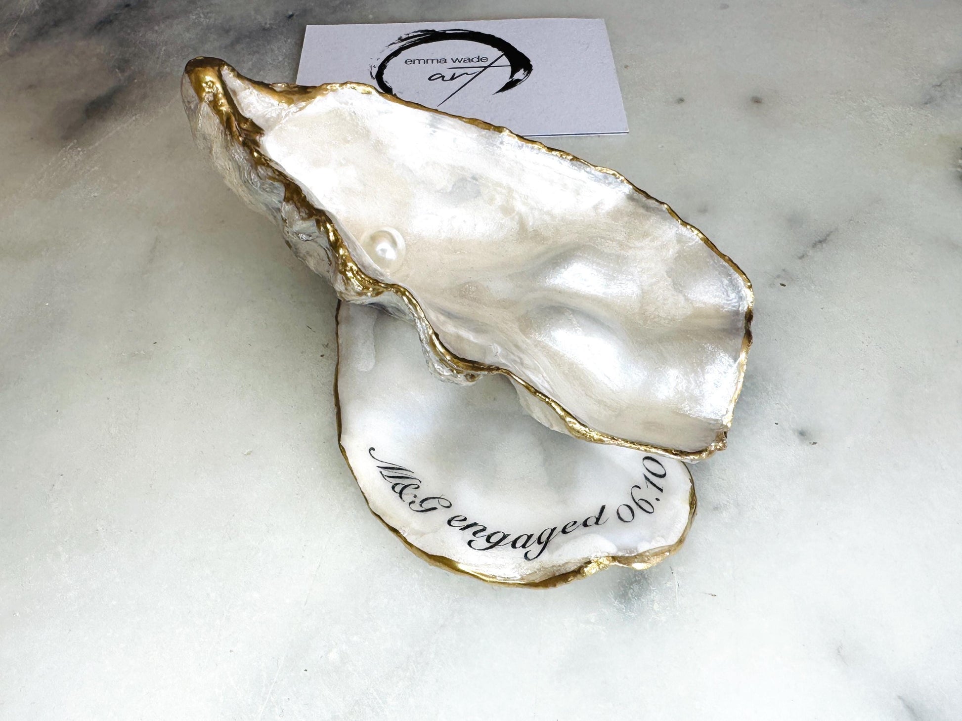 Handmade Dorset oyster shell jewellery dish set with a cupped oyster shell resting on a flat shell base, finished with natural pearl interiors and gold leaf edging. Personalised coastal trinket dish handcrafted in the UK, ideal for holding rings or jewellery. Elegant shell decor presented in sustainable gift packaging, perfect for weddings, anniversaries or special occasions.