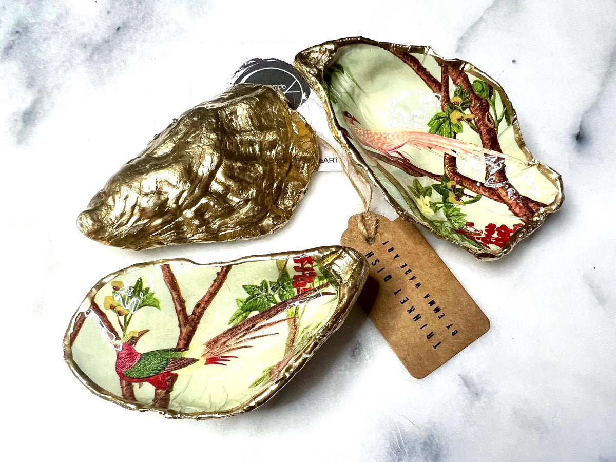 Handmade oyster shell trinket dish featuring colourful Bird of Paradise artwork with gold leaf edging and glossy resin finish. Tropical coastal jewellery dish crafted from natural Dorset shells, styled as a ring holder, keepsake tray, or exotic nature-inspired gift.