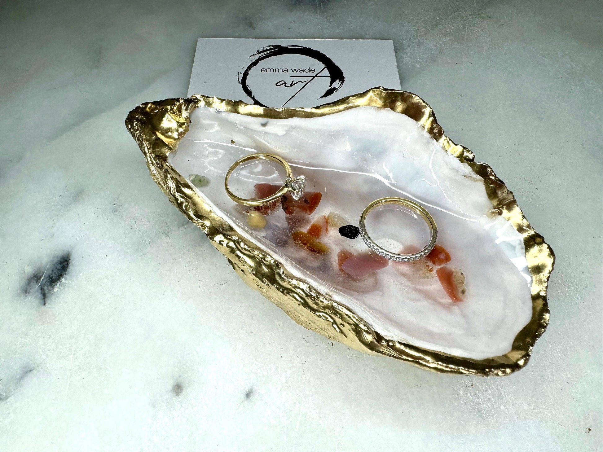 Handmade oyster shell jewellery dish with real Dorset sea glass foraged from the coast and suspended in clear glossy resin to look like a rock pool. Finished with gold leaf trim and a natural pearl interior, this unique shell dish can be used as a ring holder, jewellery tray, or trinket catcher for earrings, cufflinks, or keepsakes. A one-of-a-kind coastal-inspired gift for weddings, anniversaries, birthdays, bridesmaids, Christmas, or Mother’s Day.