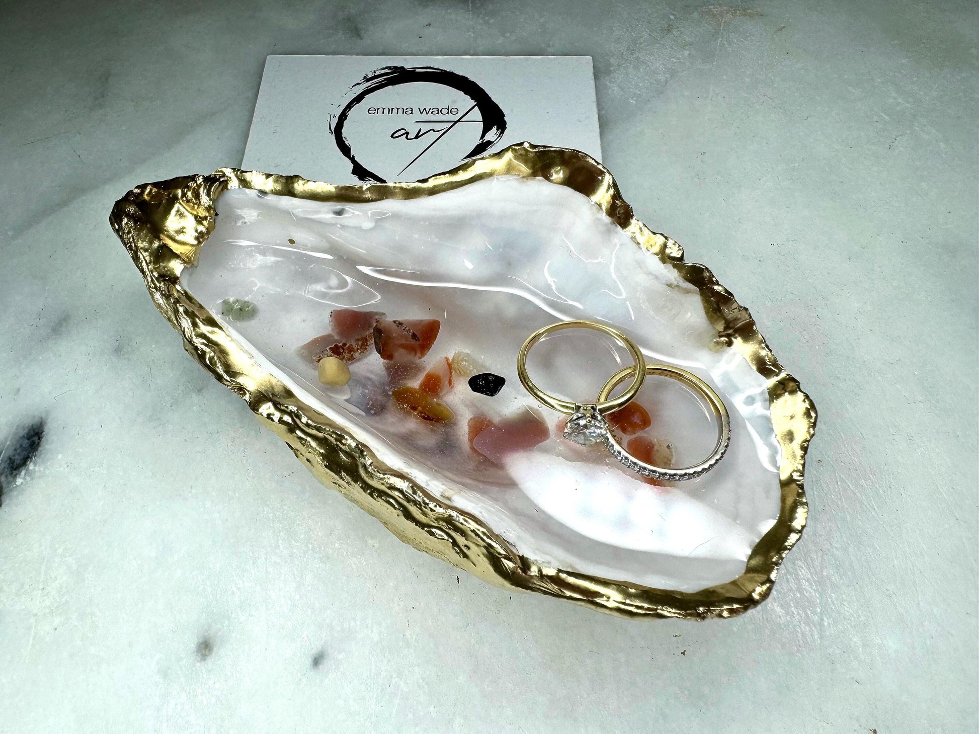 Handmade oyster shell jewellery dish with real Dorset sea glass foraged from the coast and suspended in clear glossy resin to look like a rock pool. Finished with gold leaf trim and a natural pearl interior, this unique shell dish can be used as a ring holder, jewellery tray, or trinket catcher for earrings, cufflinks, or keepsakes. A one-of-a-kind coastal-inspired gift for weddings, anniversaries, birthdays, bridesmaids, Christmas, or Mother’s Day.