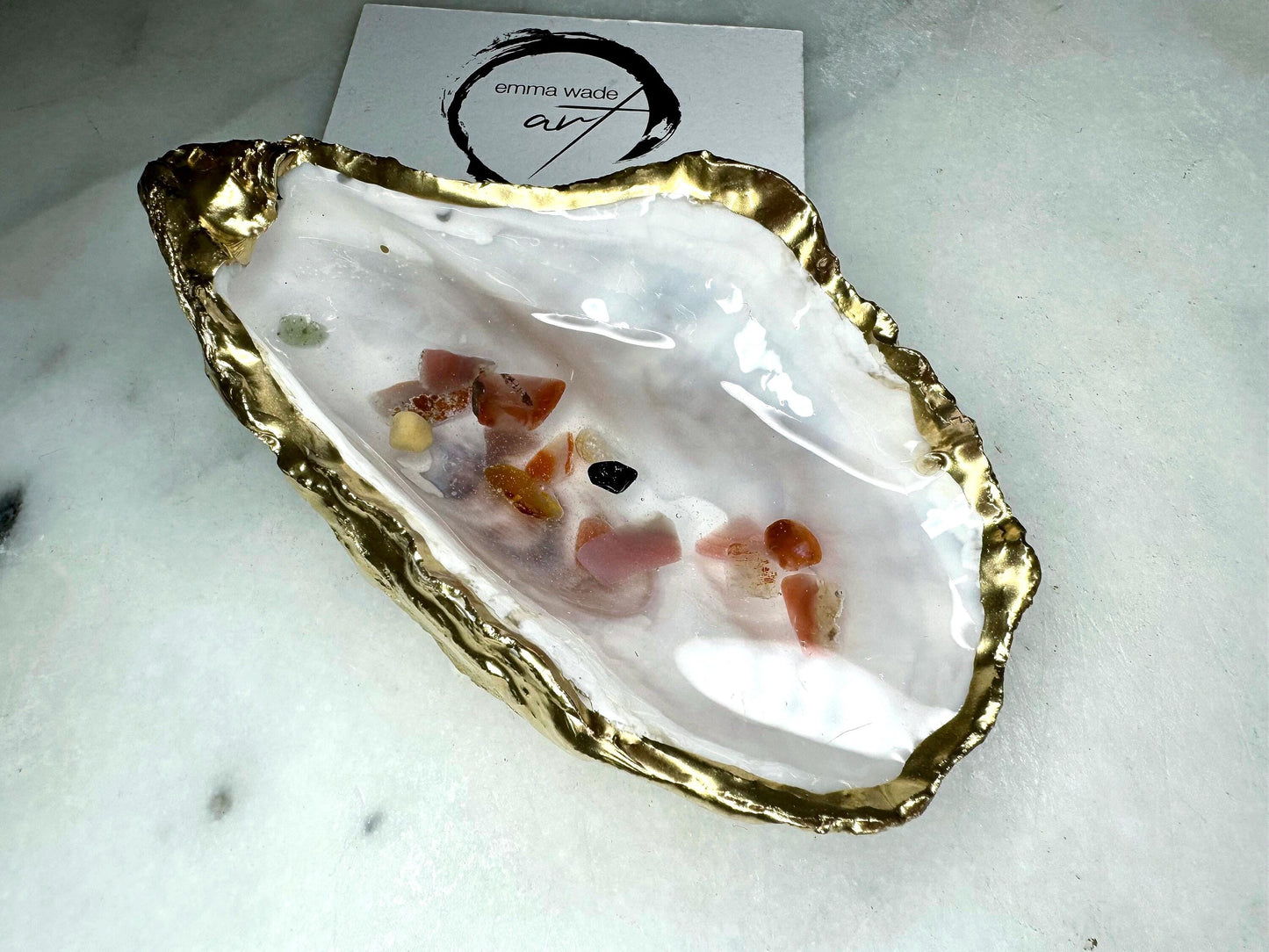 Handmade oyster shell jewellery dish with real Dorset sea glass foraged from the coast and suspended in clear glossy resin to look like a rock pool. Finished with gold leaf trim and a natural pearl interior, this unique shell dish can be used as a ring holder, jewellery tray, or trinket catcher for earrings, cufflinks, or keepsakes. A one-of-a-kind coastal-inspired gift for weddings, anniversaries, birthdays, bridesmaids, Christmas, or Mother’s Day.