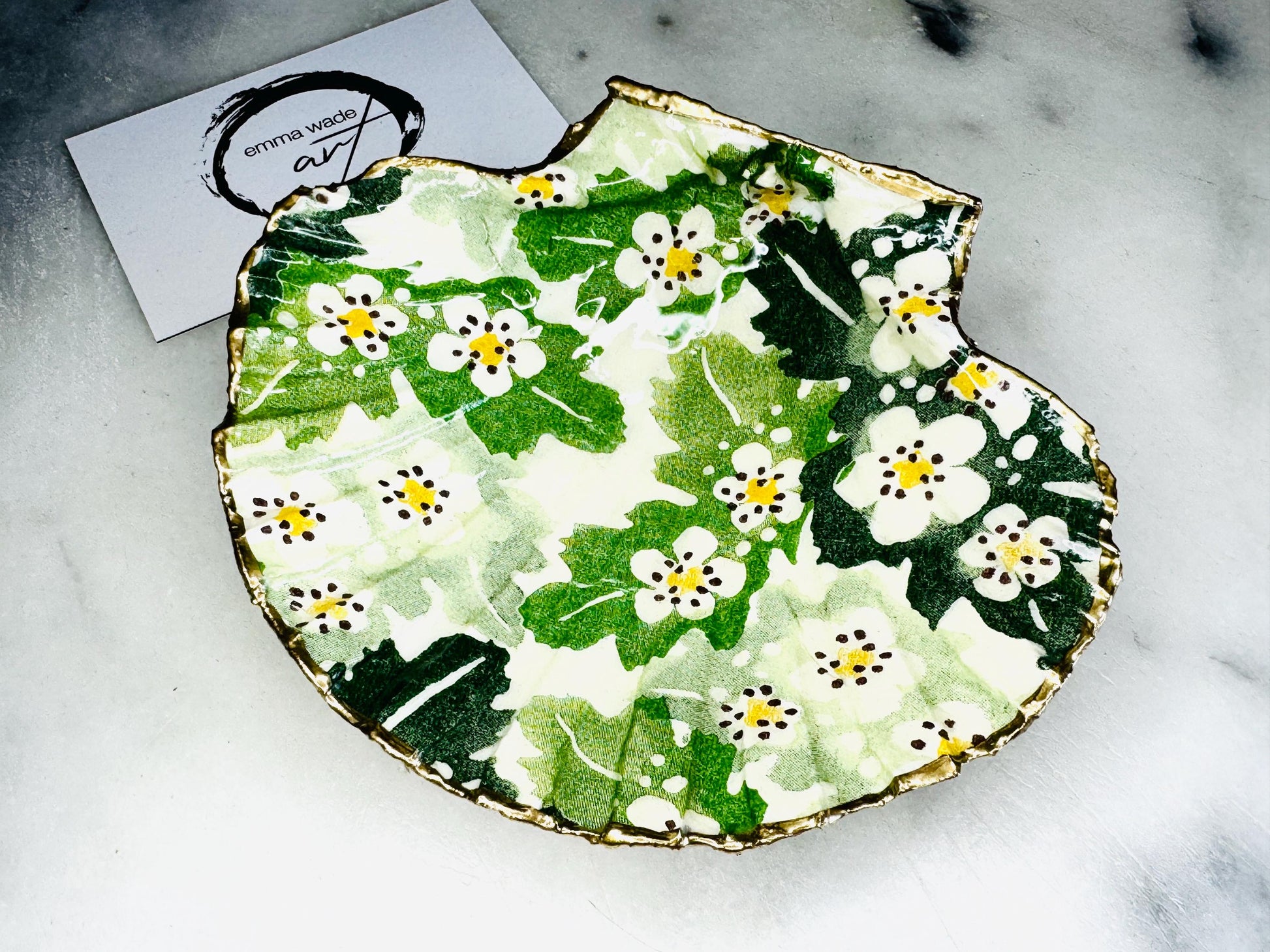 Handmade Dorset scallop shell trinket dish featuring an Emma Bridgewater inspired Hawthorn Berries floral design in green and cream tones. Decorative shell jewellery dish finished with hand-applied liquid gold leaf edging and glossy resin. Coastal cottage style ring holder and trinket tray with natural shell texture, suitable for jewellery storage, bathroom décor or gifting.