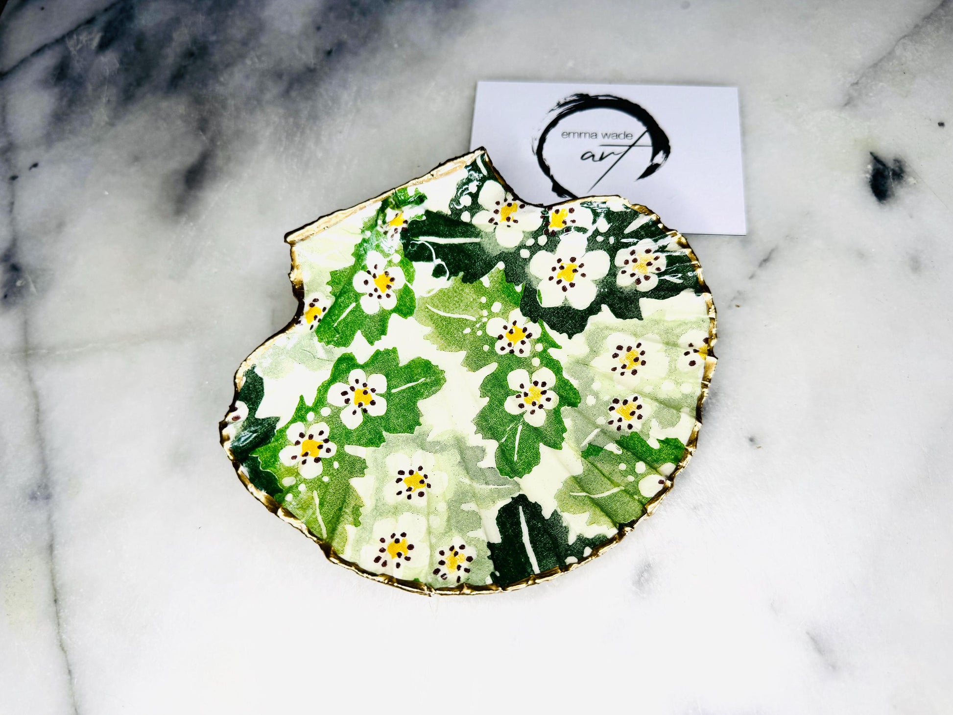 Handmade Dorset scallop shell trinket dish featuring an Emma Bridgewater inspired Hawthorn Berries floral design in green and cream tones. Decorative shell jewellery dish finished with hand-applied liquid gold leaf edging and glossy resin. Coastal cottage style ring holder and trinket tray with natural shell texture, suitable for jewellery storage, bathroom décor or gifting.