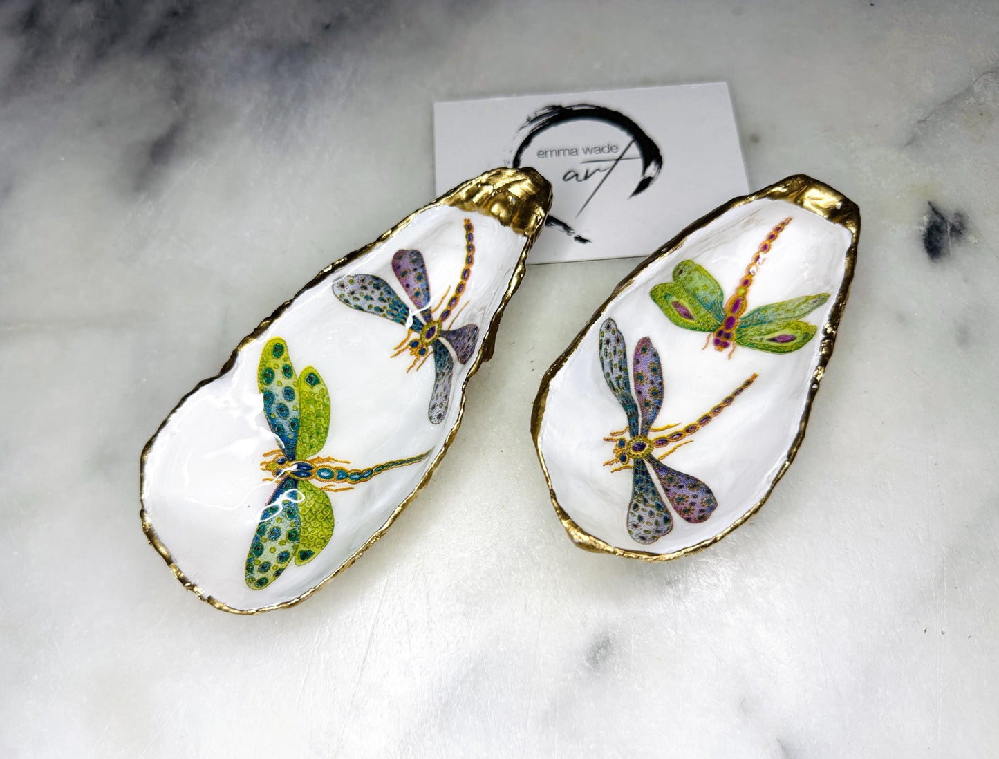 Handmade dragonfly oyster shell trinket dish with hand-gilded gold leaf edges and glossy resin finish, created from sustainably sourced Dorset shells. Unique coastal jewellery holder and ring dish, ideal as a vanity tray, trinket tray or decorative keepsake. Nature inspired home decor gift for birthdays, weddings, anniversaries, housewarmings and Mother’s Day. One of a kind artisan shell dish, beautifully presented in a gift box.