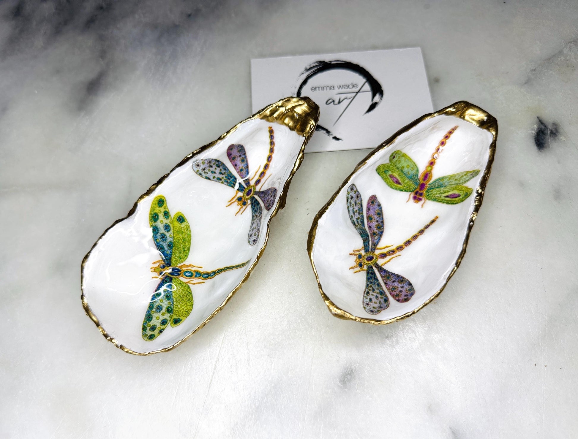Handmade dragonfly oyster shell trinket dish with hand-gilded gold leaf edges and glossy resin finish, created from sustainably sourced Dorset shells. Unique coastal jewellery holder and ring dish, ideal as a vanity tray, trinket tray or decorative keepsake. Nature inspired home decor gift for birthdays, weddings, anniversaries, housewarmings and Mother’s Day. One of a kind artisan shell dish, beautifully presented in a gift box.