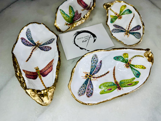 Handmade dragonfly oyster shell trinket dish with hand-gilded gold leaf edges and glossy resin finish, created from sustainably sourced Dorset shells. Unique coastal jewellery holder and ring dish, ideal as a vanity tray, trinket tray or decorative keepsake. Nature inspired home decor gift for birthdays, weddings, anniversaries, housewarmings and Mother’s Day. One of a kind artisan shell dish, beautifully presented in a gift box.