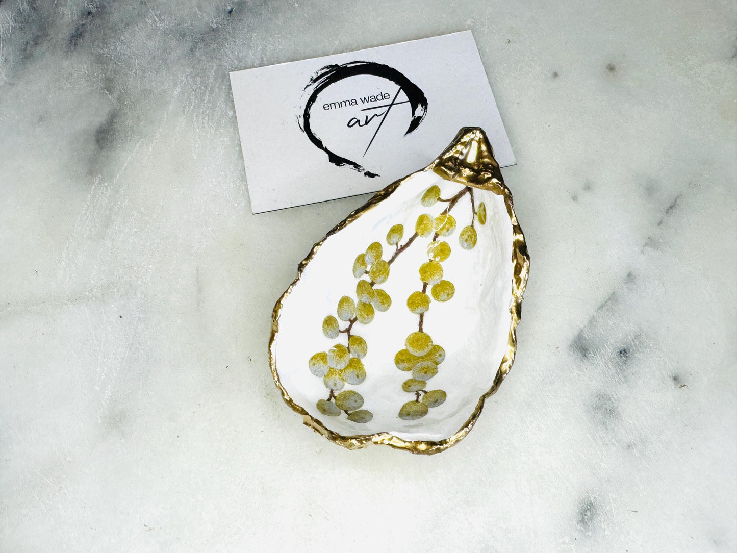 Handmade Dorset oyster shell dish with a gold and white berries design, gilded with liquid gold leaf on the rim and back, and sealed in crystal-clear resin for a glossy shine. Each oyster shell jewellery dish is unique, perfect as a ring holder, trinket tray, or organiser for earrings, cufflinks, and small keepsakes. A meaningful handmade oyster ring dish for weddings, anniversaries, birthdays, bridesmaids, or festive celebrations. Ideal as UK coastal-inspired home décor.
