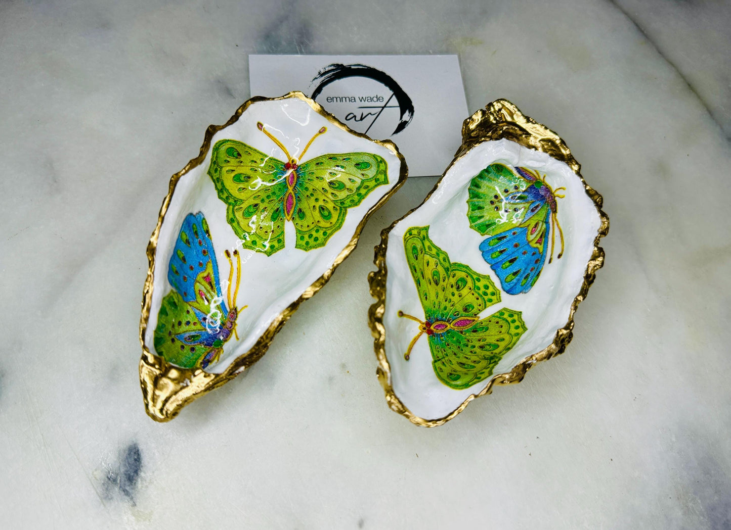 Handmade butterfly oyster shell trinket dish with colourful blue green and pink butterfly designs, edged and backed in gold leaf, Dorset coastal shell jewellery holder with glossy resin finish, luxury ring dish, coastal home decor gift, unique handmade shell dish for jewellery storage, beach house accessory, UK artisan oyster shell dish