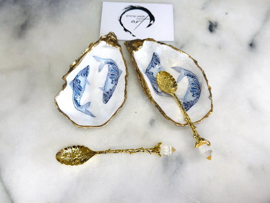 Handmade Dorset oyster shell salt and pepper pinch pots featuring blue paisley fish designs with gold leaf edging and glossy resin finish. Coastal oyster shell cruet set with natural pearlescent interiors and optional gold spoons, styled as elegant nautical table décor and condiment dishes.