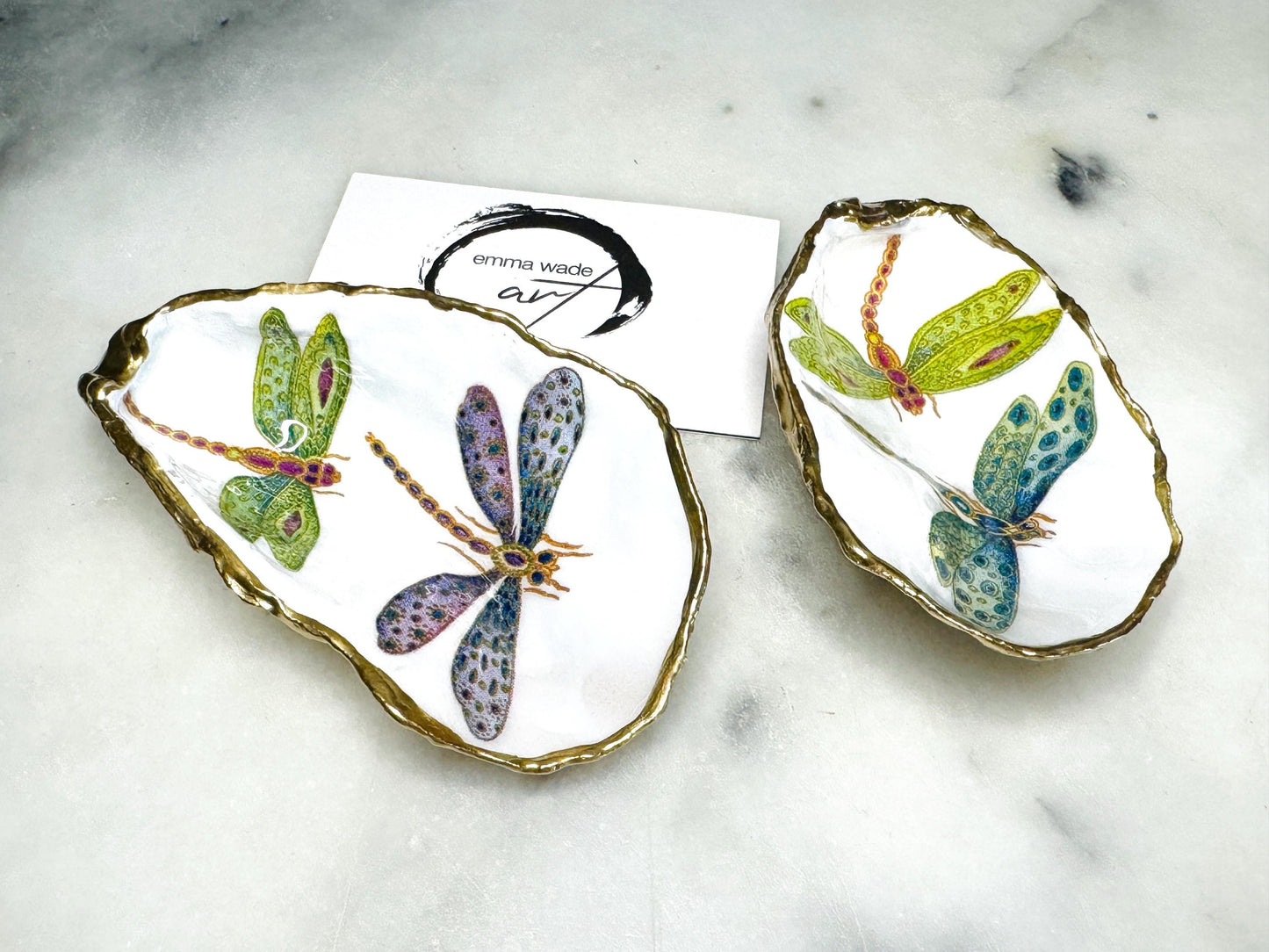 Handmade dragonfly oyster shell trinket dish with hand-gilded gold leaf edges and glossy resin finish, created from sustainably sourced Dorset shells. Unique coastal jewellery holder and ring dish, ideal as a vanity tray, trinket tray or decorative keepsake. Nature inspired home decor gift for birthdays, weddings, anniversaries, housewarmings and Mother’s Day. One of a kind artisan shell dish, beautifully presented in a gift box.
