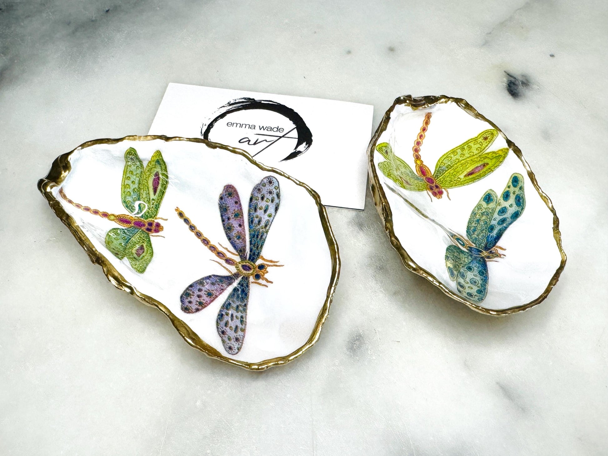 Handmade dragonfly oyster shell trinket dish with hand-gilded gold leaf edges and glossy resin finish, created from sustainably sourced Dorset shells. Unique coastal jewellery holder and ring dish, ideal as a vanity tray, trinket tray or decorative keepsake. Nature inspired home decor gift for birthdays, weddings, anniversaries, housewarmings and Mother’s Day. One of a kind artisan shell dish, beautifully presented in a gift box.